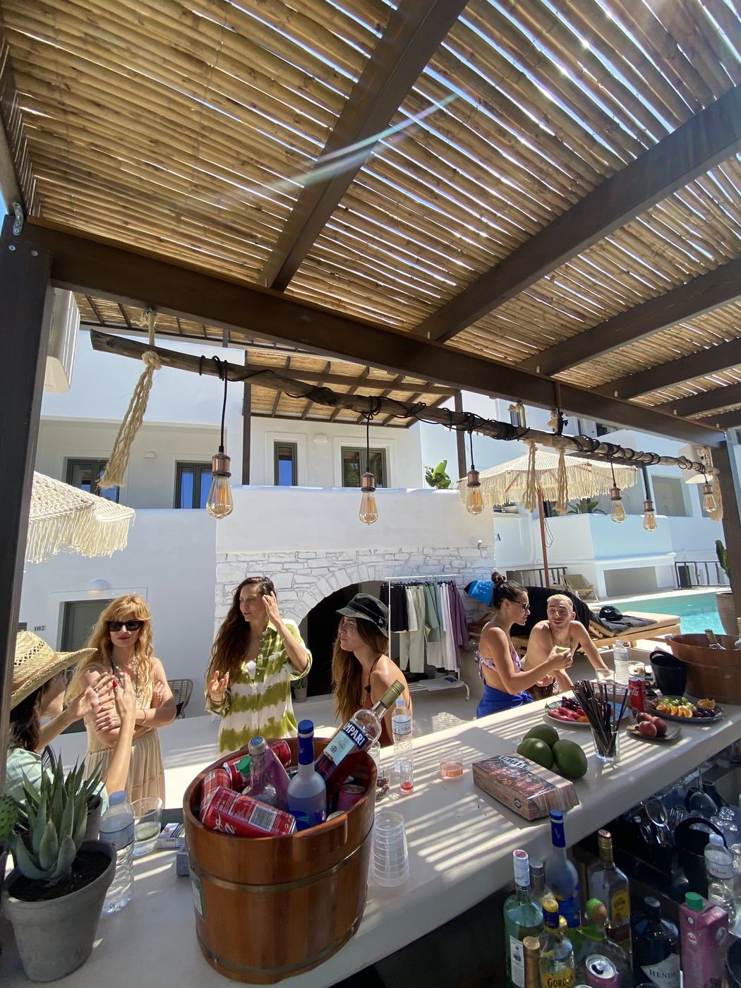 A pool bar at a private Paros property — bamboo pergola, late afternoon